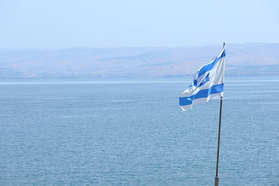 Flag of israel on sea against sky