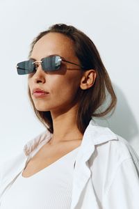 Young woman wearing sunglasses against white background