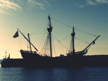 Silhouette ship on sea against sky during sunset