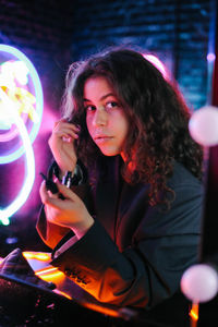 Portrait of young woman holding illuminated lights