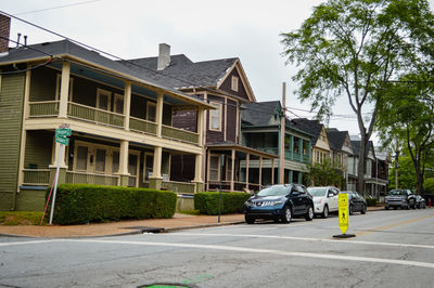 Cars on street by buildings against sky