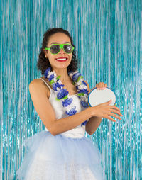 Portrait of young woman wearing sunglasses while standing against decorations