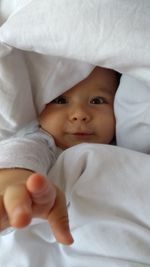 Close-up portrait of cute baby on bed at home