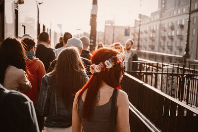 Rear view of people walking on street in city