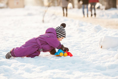 Girl playing with toy on snow