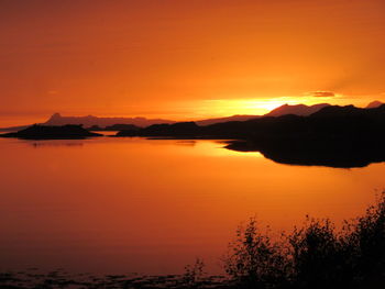 Scenic view of sea against dramatic sky during sunset