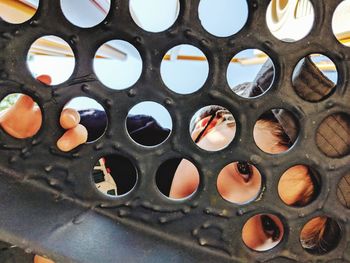 Boy peeking through patterned metal