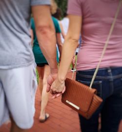 Low section of couple holding hands