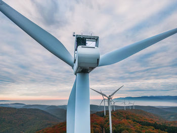 Close-up on the propellers of a wind turbine during a misty morning and sunrise. green energy. 