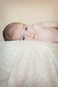 Portrait of cute baby lying on bed
