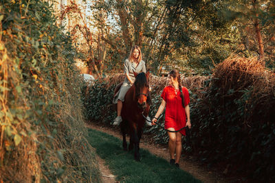 People walking on road amidst trees