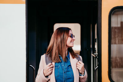 Woman looking away while standing in train