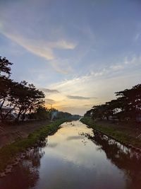 Scenic view of river against sky at sunset
