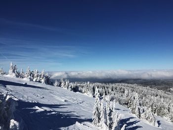 Scenic view of snowcapped mountains against blue sky