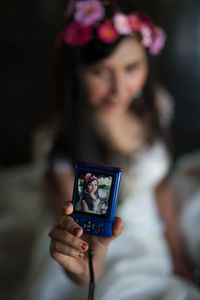 Close-up of young woman taking selfie through digital camera