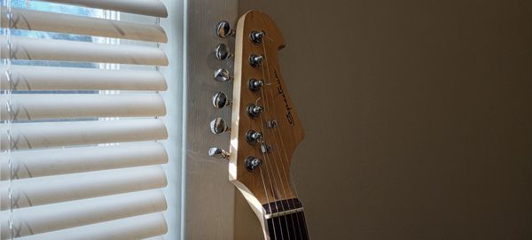 Close-up of guitar against wall