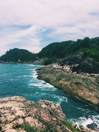 Scenic view of sea and mountains against sky