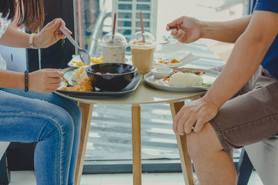 Midsection of people at restaurant table