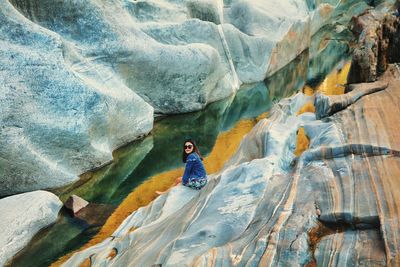 High angle view of woman sitting on rock formation