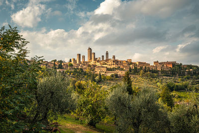 Buildings in medieval city on hilltop against cloudy sky