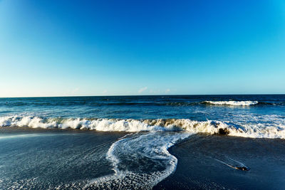Scenic view of sea against clear blue sky