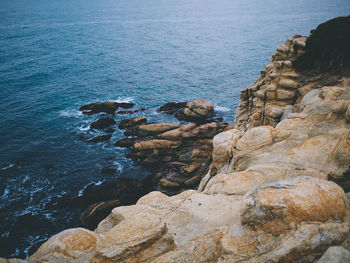 Rock formation in sea against sky