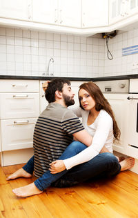 Romantic young couple sitting in kitchen
