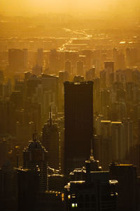 Aerial view of modern buildings in city at sunset
