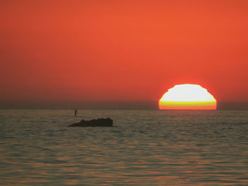 Scenic view of sea against orange sky