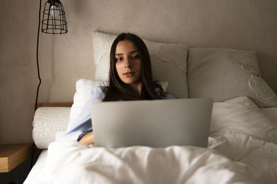 Woman using laptop in bed