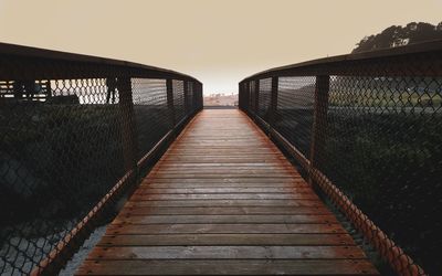 Empty footbridge against clear sky