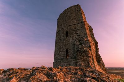 Low angle view of rock formation against sky during sunset