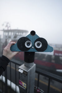 Close-up of binoculars against sky
