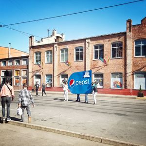 People walking on road against buildings