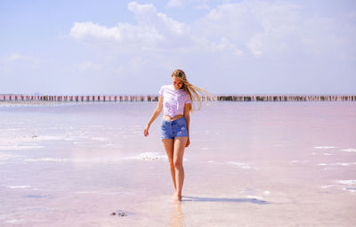 Girl in shorts and t-shirt on a salty pink lake in sunny  weather