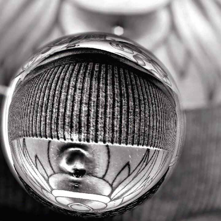 focus on foreground, close-up, indoors, selective focus, still life, hanging, single object, metal, no people, pattern, day, part of, man made object, sphere, detail, feather, wood - material, arts culture and entertainment, shiny