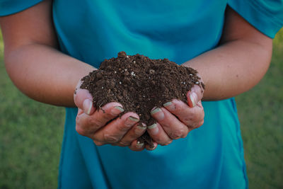 Midsection of woman holding dirt 