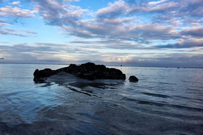 Scenic view of rocks in sea against sky