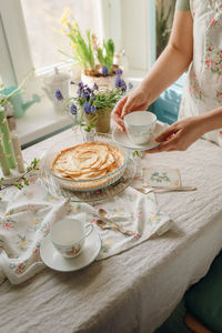 Midsection of woman having food on table