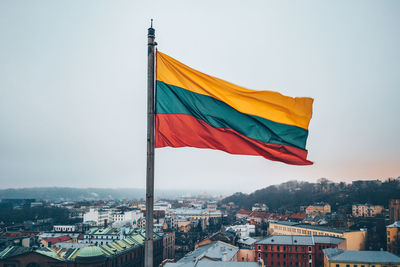 Flag against sky in city