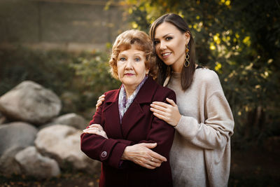 Portrait of senior woman with daughter standing in park