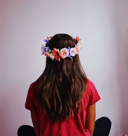 Rear view of girl standing against pink flowers