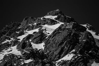 Low angle view of snowcapped mountains against clear sky