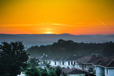 High angle view of townscape against orange sky