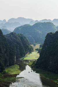 Scenic view of river amidst mountains against clear sky