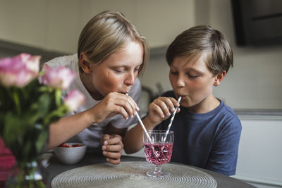 Close-up of girl drinking glass at home