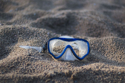 Close-up of sunglasses on sand