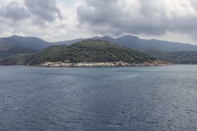 Scenic view of sea and mountains against sky