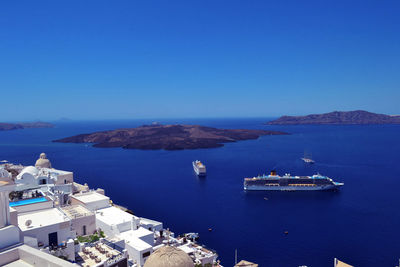 High angle view of town by sea against clear sky