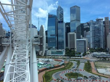 Modern buildings against sky with ferris wheel on foreground